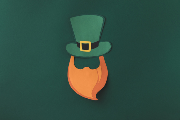 top view of paper decoration of man in green hat for st patricks day isolated on green - Foto, afbeelding