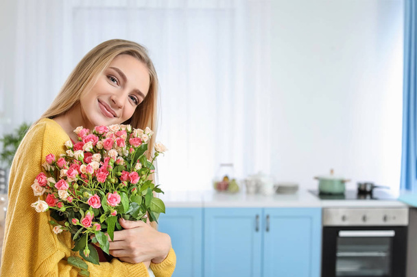 Beautiful young woman with bouquet of roses at home - Φωτογραφία, εικόνα