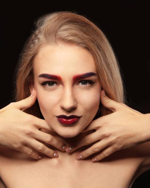 Young woman with dyed eyebrows on black background - Fotografie, Obrázek