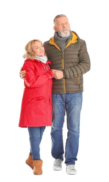 Mature couple in warm clothes walking on white background - Foto, immagini