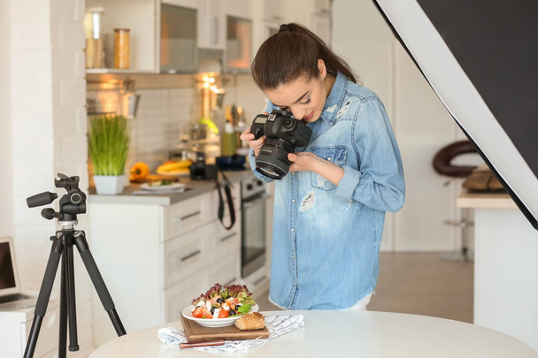 Young woman with professional camera taking still life pictures in kitchen - Foto, immagini