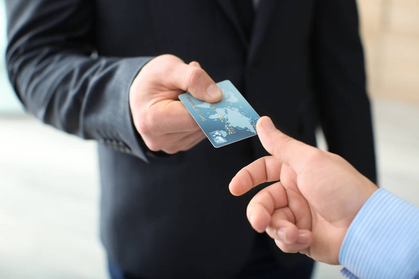 Businessman giving credit card to man, closeup - Fotó, kép