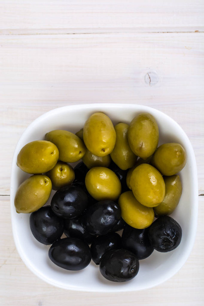 Білий салат з зеленими та чорними оливками
 - Фото, зображення