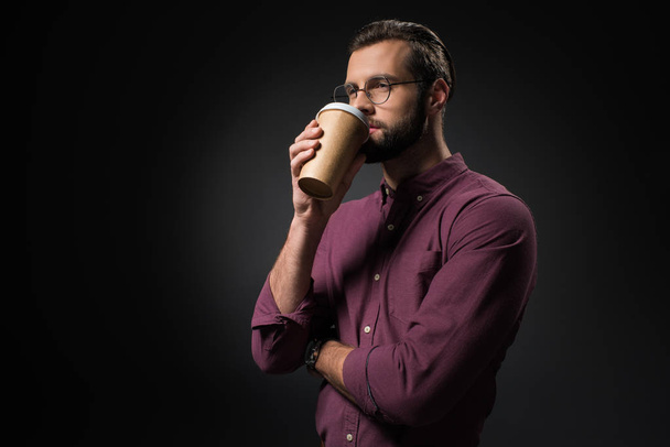 portrait of businessman drinking coffee to go isolated on black - Photo, Image