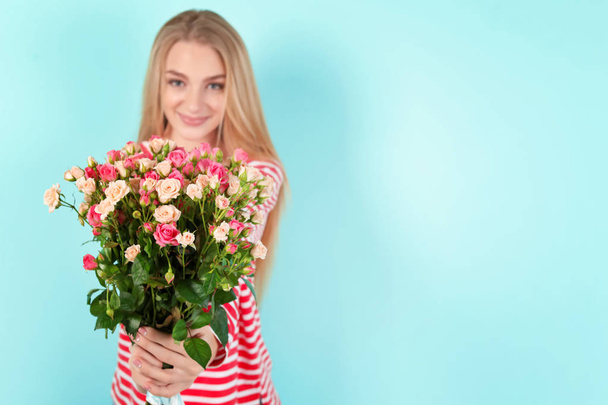 Beautiful young woman with bouquet of roses on color background - Photo, Image