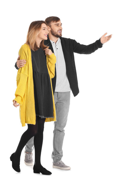 Young couple in casual clothes walking on white background - Foto, afbeelding