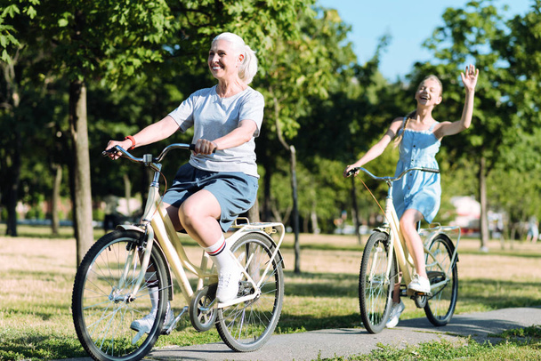 Mujer anciana encantada montando una bicicleta
 - Foto, Imagen