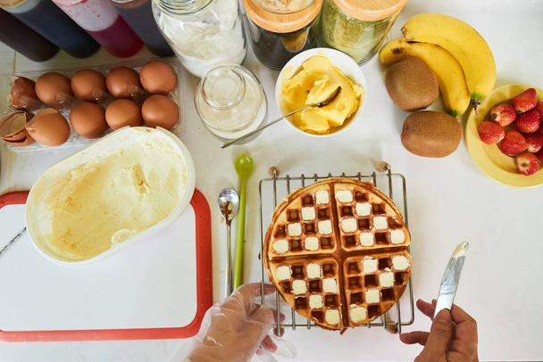 Baker adding ice-cream on waffle in checkerboard pattern - Foto, afbeelding