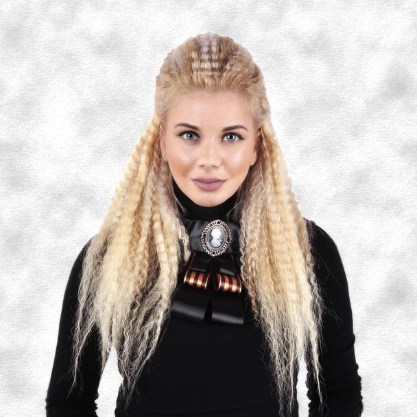 Siyah kazaklı bir broş ile uzun sarı saçlı genç kız - Fotoğraf, Görsel