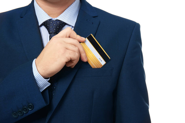 Man putting credit card in pocket on white background - Foto, imagen