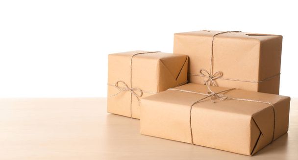 Parcel gift boxes on wooden table against white background - Foto, immagini