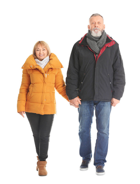 Mature couple in warm clothes walking on white background - Foto, imagen