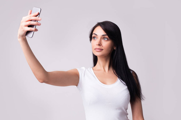 young brunette woman in casual clothes making selfie - Photo, Image