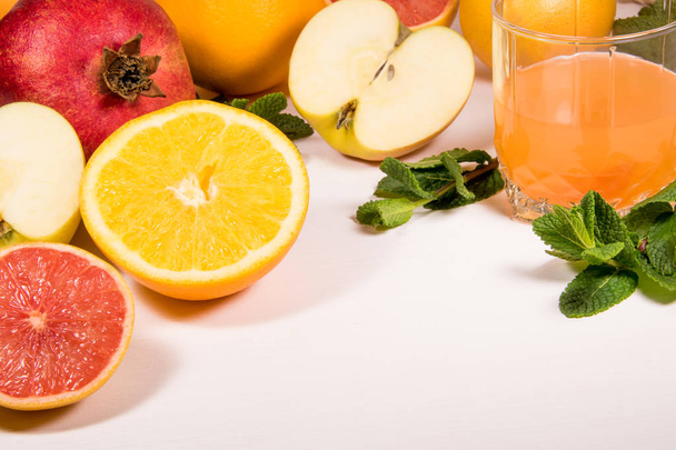 A vitamin set on a white background fruit and citrus apples grapefruit orange ginger mint and blander Healthy eating glass of juice copyspace - Foto, afbeelding