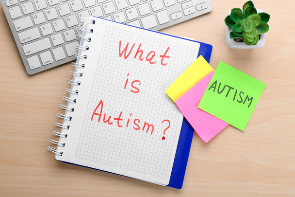 Notebook with phrase "What is autism?" on table - Foto, Imagen