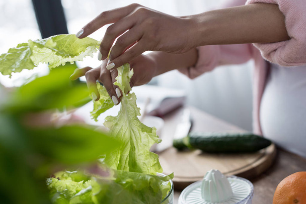 cropped view of woman taking green salad at kitchen - Foto, Imagem