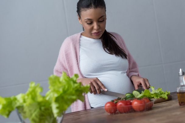 afro-américaine enceinte faisant de la salade à la cuisine
 - Photo, image