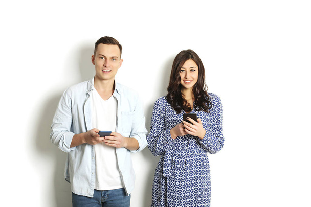 Young couple checking mobile phone, reading a message. Technology & relationship concept. Modern romance troubles. Male & female online dating app. Touch screen, chatting, swiping, browsing, surfing. - Photo, image