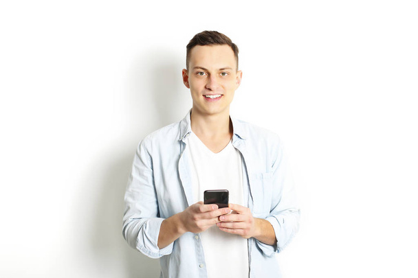 Young man checking mobile phone, reading a message. Technology & relationship concept. Modern romance troubles. Male & female online dating app. Touch screen, chatting, swiping, browsing, surfing. - Fotó, kép