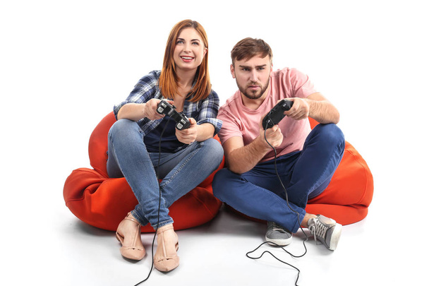 Emotional couple playing video game on white background - Fotografie, Obrázek