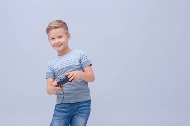 Cute boy with video game controller on color background - Φωτογραφία, εικόνα