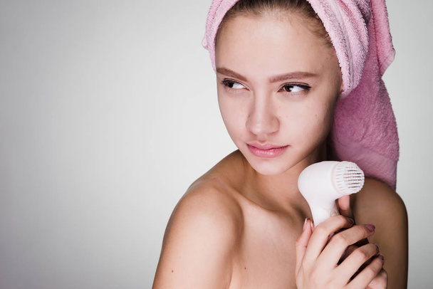 woman with towel on her head after shower holding a brush for deep cleaning - Φωτογραφία, εικόνα
