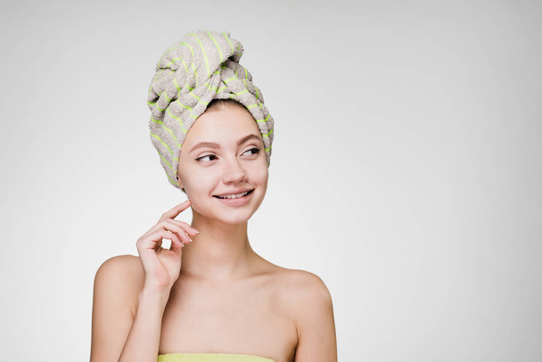 happy woman with towel on her head after shower looks away - Zdjęcie, obraz