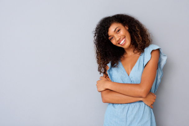 Retrato de feliz jovem afro-americana sorrindo contra fundo cinza
 - Foto, Imagem