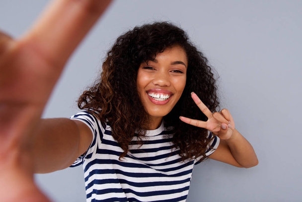 Portrait of happy young woman smiling and taking selfie - Photo, Image
