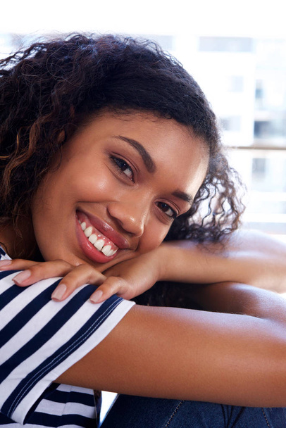 Εσωτερικη πορτρέτο του happy νεαρό μαύρο όμορφη γυναίκα χαμογελώντας  - Φωτογραφία, εικόνα