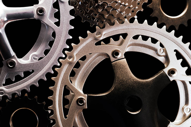 Nahaufnahme verschiedener Arten von Fahrradgetriebe auf schwarzem Hintergrund - Foto, Bild