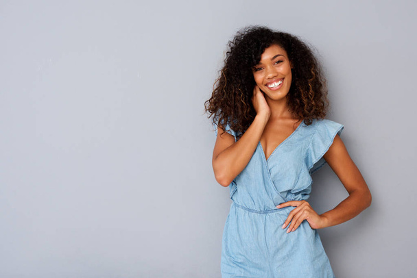 Retrato horizontal de una hermosa joven afroamericana sonriendo sobre un fondo gris
 - Foto, imagen