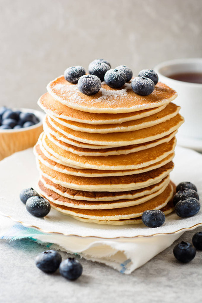 Pancakes with blueberries and sugar on grey stone background. - Фото, изображение