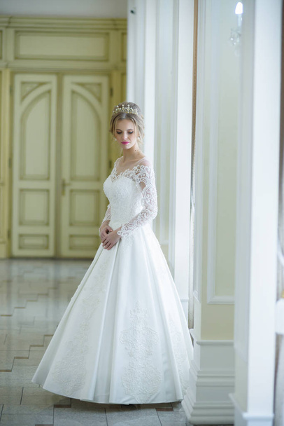 Beautiful bride in a wedding dress white interior - 写真・画像