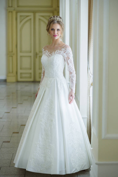 Beautiful bride in a wedding dress white interior - Foto, immagini