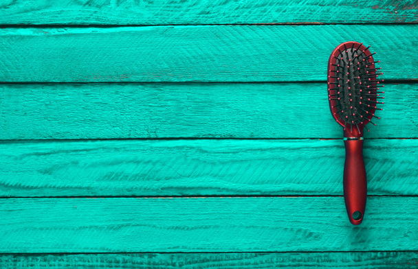 Female comb on a wooden turquoise background. Trend of minimalism. Top view. Copy space. - Photo, Image