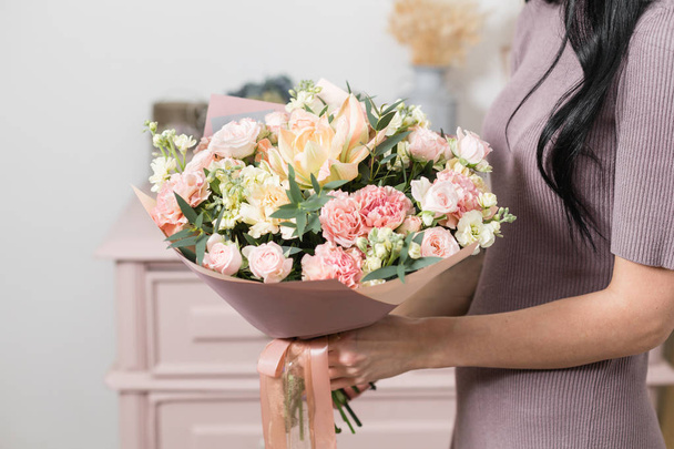 piękny, luksusowy bukiet z mieszanych kwiatów w ręce kobiety. Praca w kwiaciarni Kwiaciarnia. - Zdjęcie, obraz