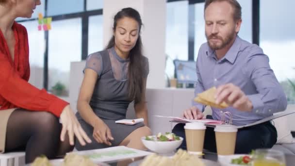 4K Corporate business team looking over the figures in informal meeting - Footage, Video