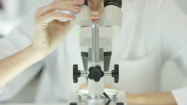 4K Close up of medical researcher working in the lab looking into microscope - Materiaali, video