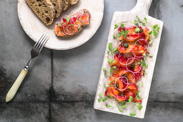Saumon salé à l'oignon, légumes et pain, plat scandinave
 - Photo, image
