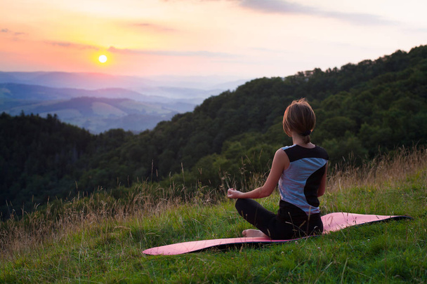 Frau bei Yoga-Meditation in den Bergen im Morgengrauen - Foto, Bild
