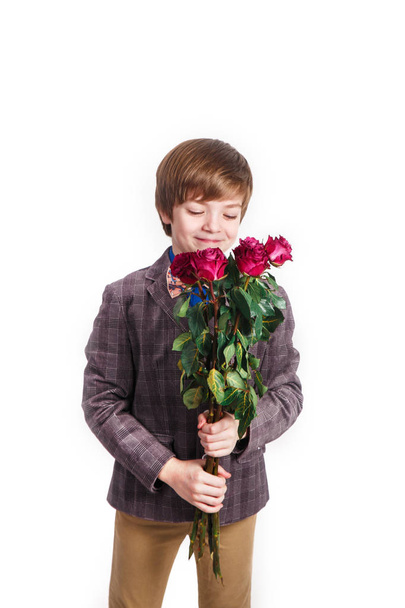 Улыбающийся мальчик с букетом красных роз. День святого Валентина, 8 марта, День матери
 - Фото, изображение
