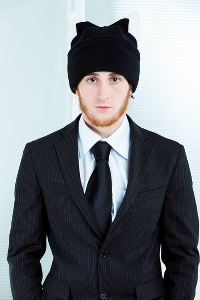 Extraño hombre de negocios con una gorra y un traje de punto
 - Foto, Imagen