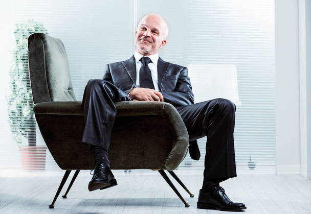 Hombre de negocios relajado con una sonrisa satisfecha
 - Foto, Imagen