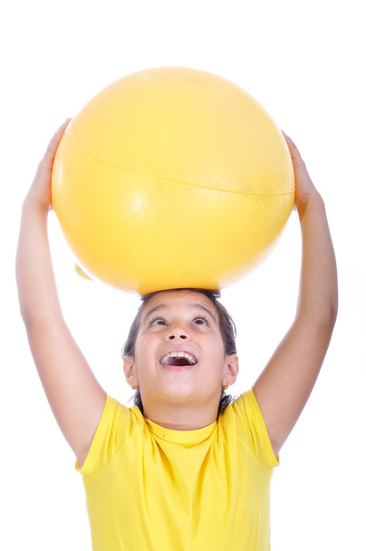 Little girl with yellow ball on head - Foto, afbeelding