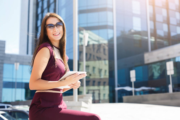 Souriant jeune femme d'affaires avec tablette à l'extérieur
 - Photo, image