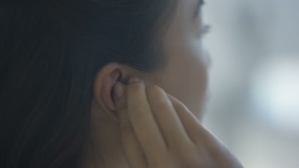4k Frau mit Gehörlosigkeit setzt Hörgerät ins Ohr  - Filmmaterial, Video