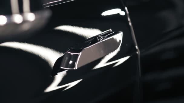 Slomotion materiał z chrome opalony klamka wyciąga i następnie z powrotem w drzwi nowego samochodu czarny. - Materiał filmowy, wideo