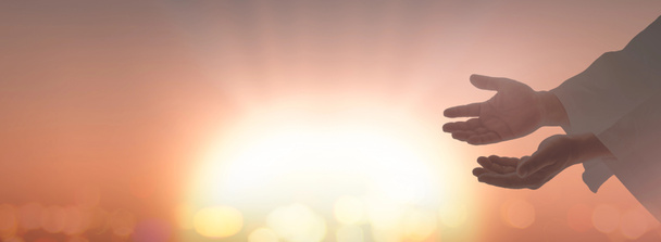 Ostersonntagskonzept: Silhouette Jesuschrist öffnet spirituelle Hände über verschwommenem Sonnenuntergang. - Foto, Bild