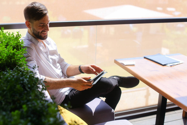 Uomo d'affari europeo che utilizza tablet al tavolo del caffè
. - Foto, immagini